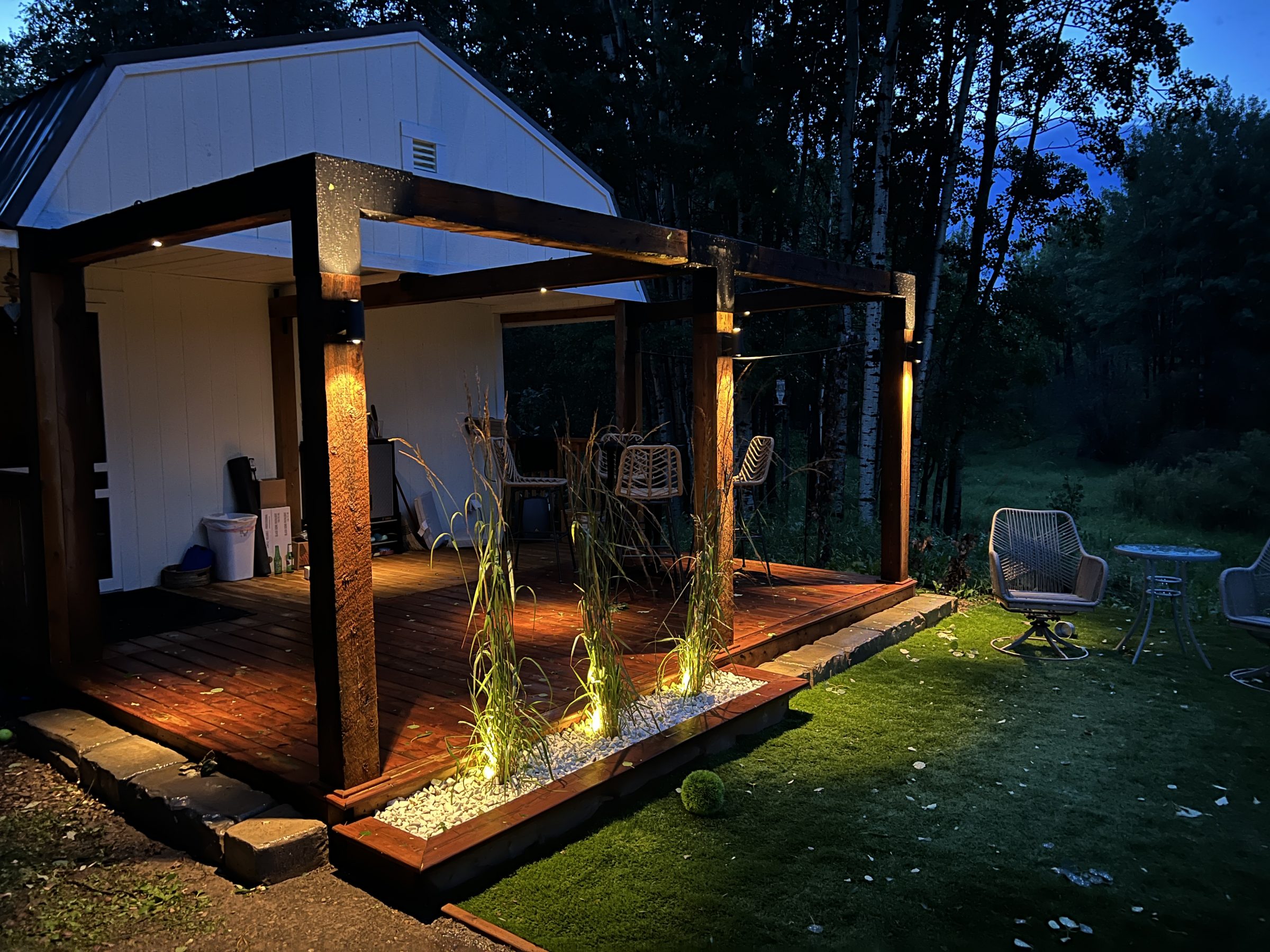 Modern backyard patio with pergola lighting at dusk