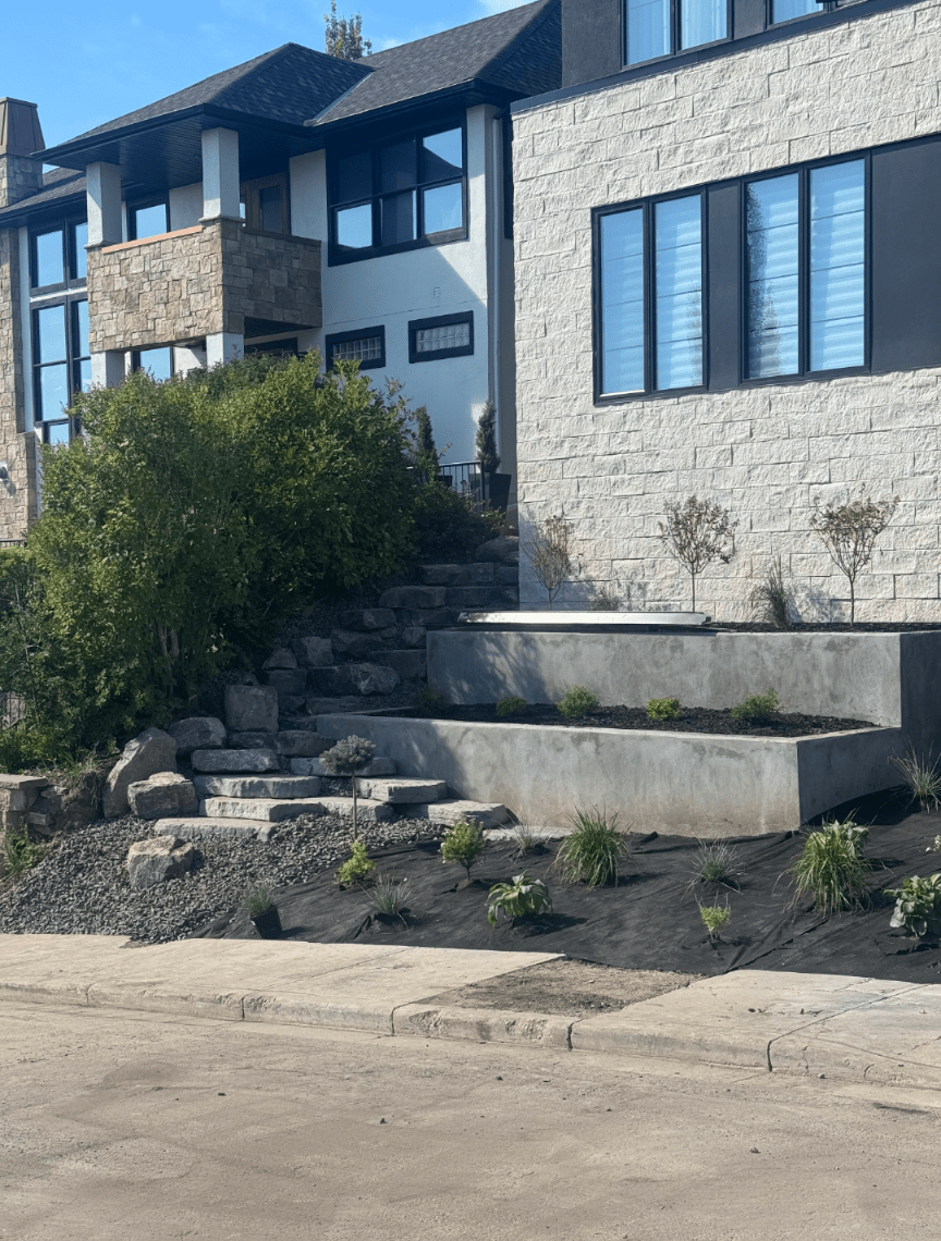 Modern stone house with terraced landscaping and steps