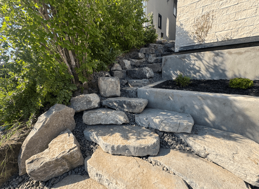 Natural stone steps beside landscaped house exterior