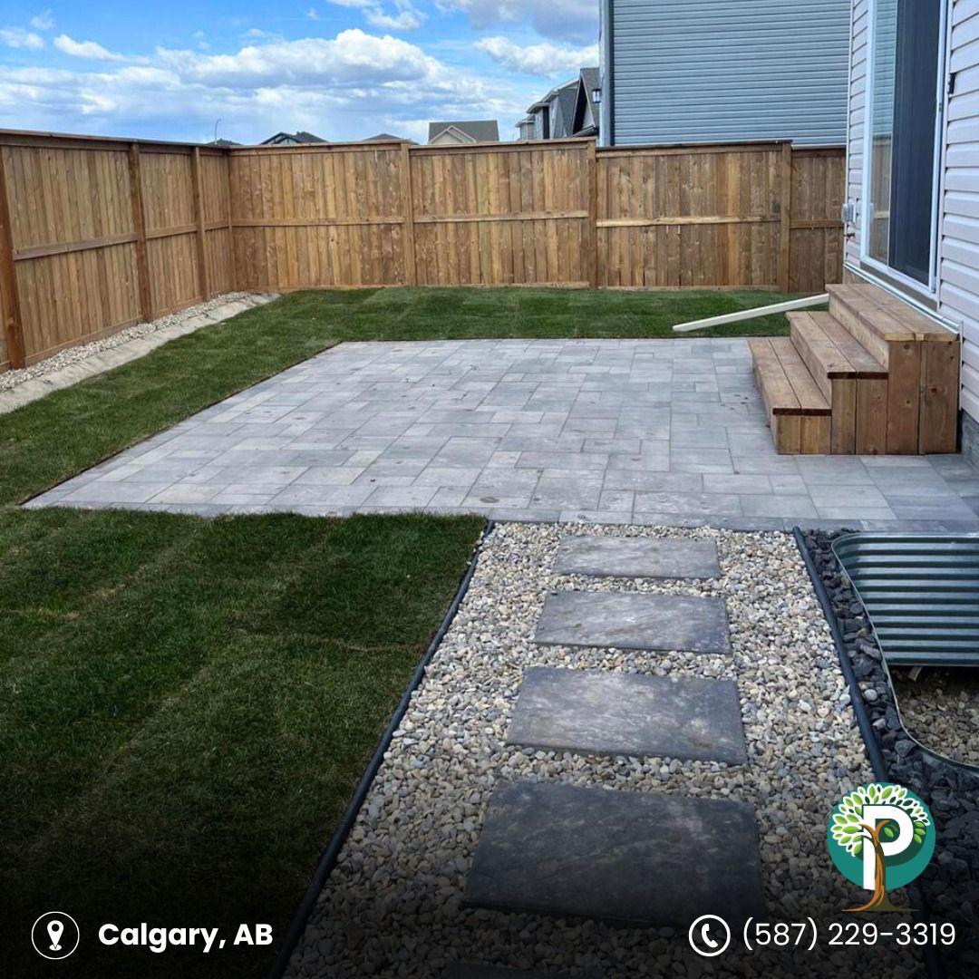 Landscaped backyard with stone patio and wooden steps