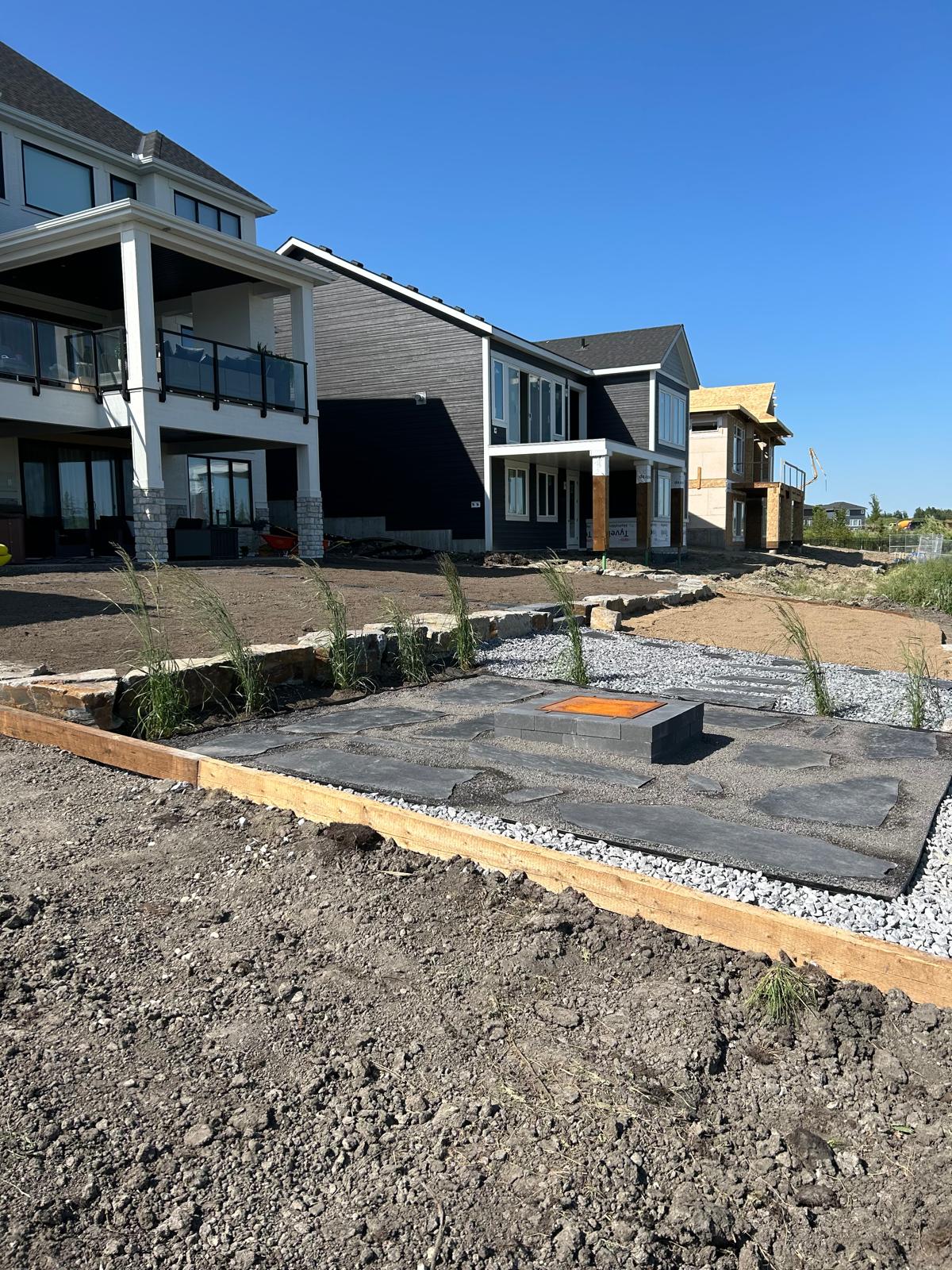 Modern backyard patio with fire pit under construction