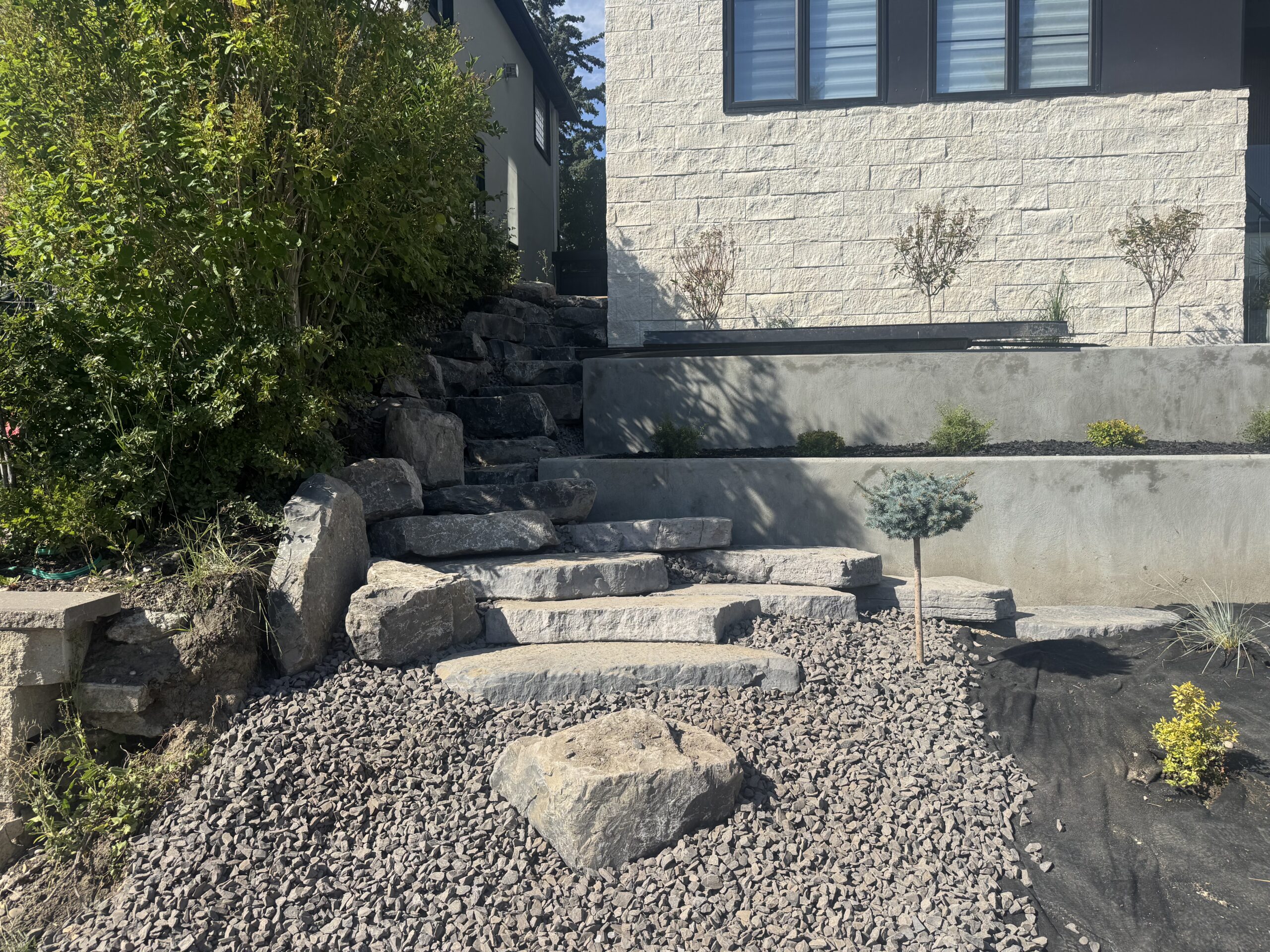 Stone steps and terraced landscaping beside modern home