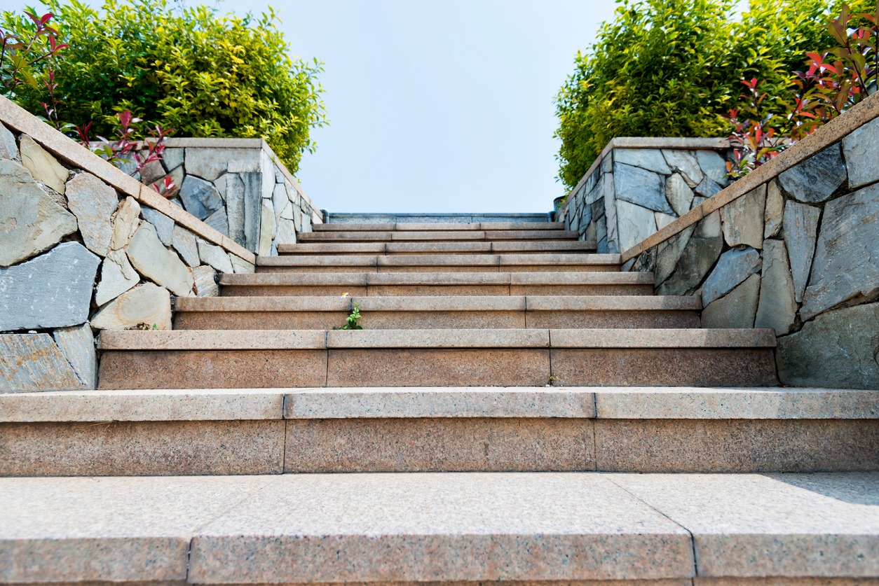 Stone staircase bordered by walls and greenery