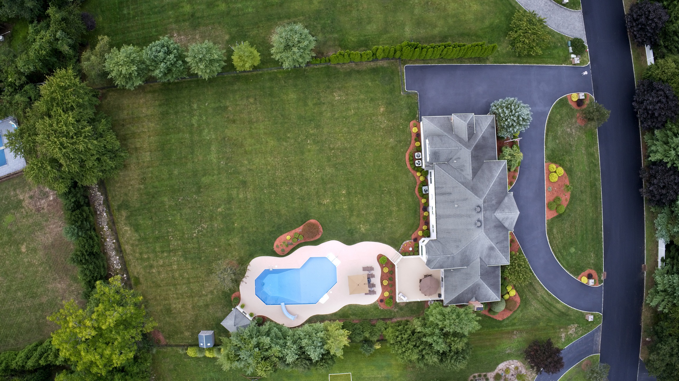 Aerial view of suburban home with backyard pool