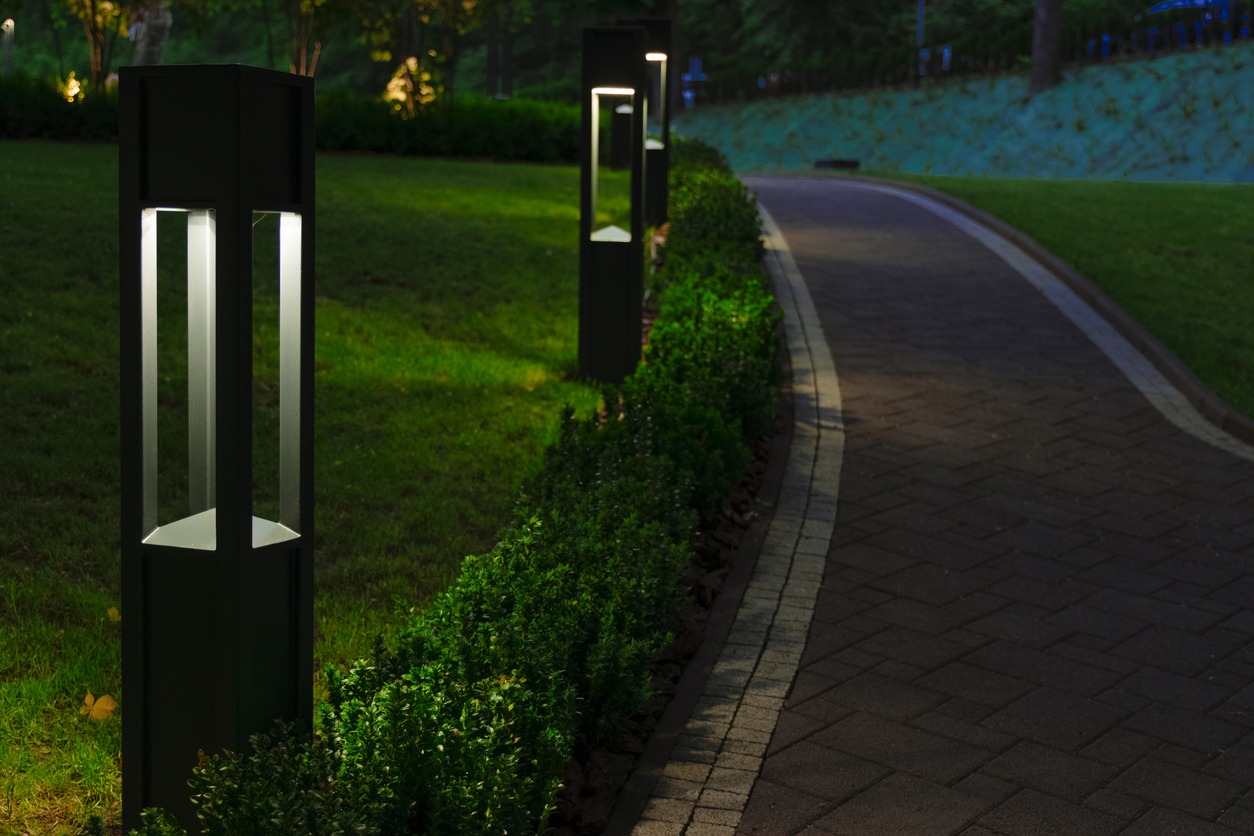 Modern bollard lights along curved garden pathway at night