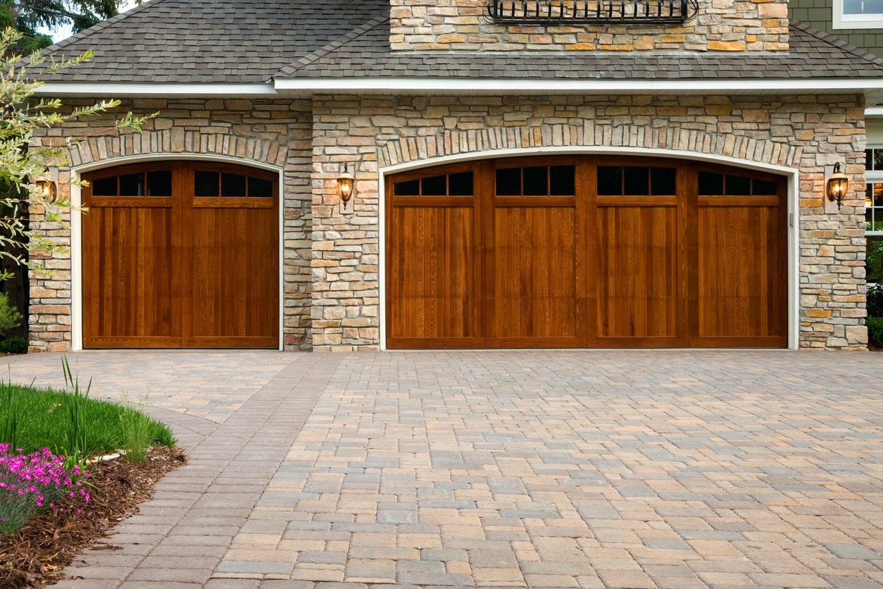 Stone house with wooden double garage doors