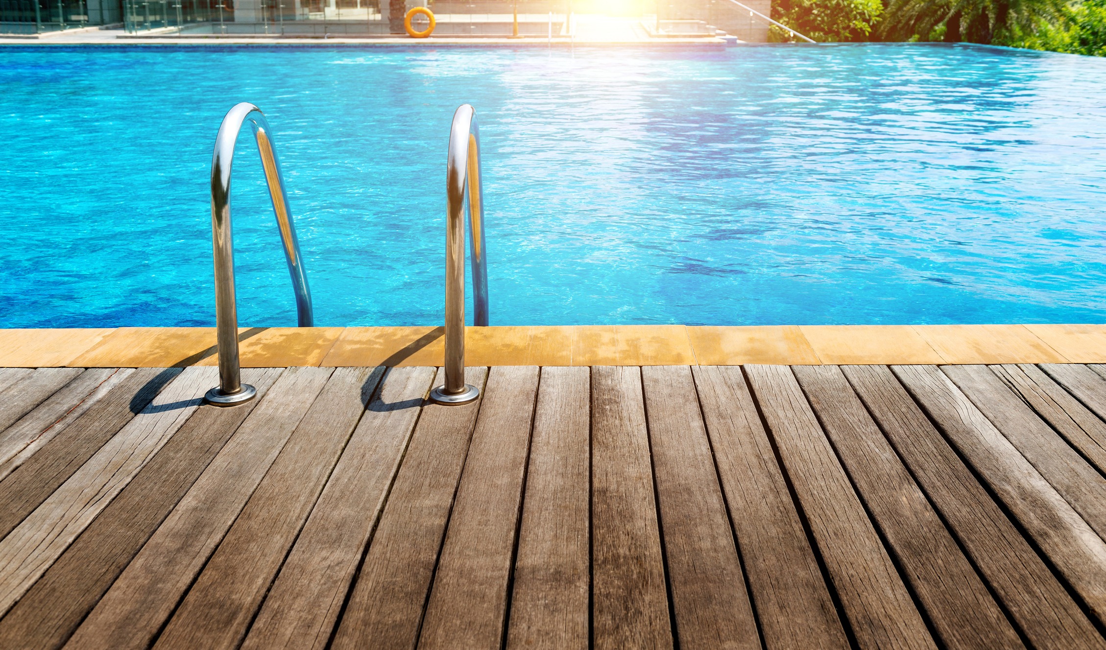 Metal ladder beside clear blue swimming pool
