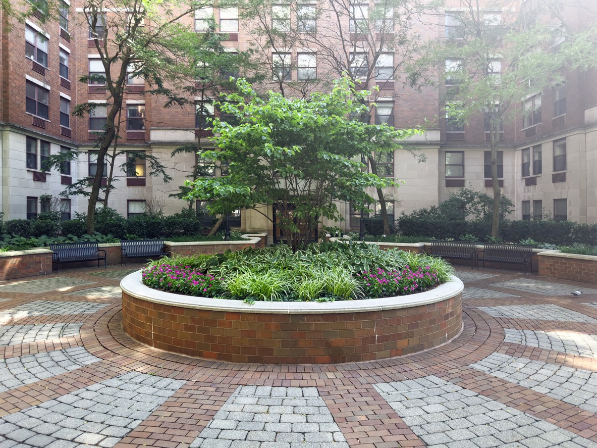 Circular brick planter in apartment courtyard garden