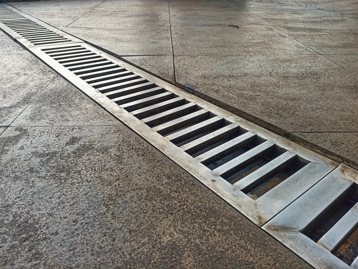 Long metal drainage grate in concrete pavement