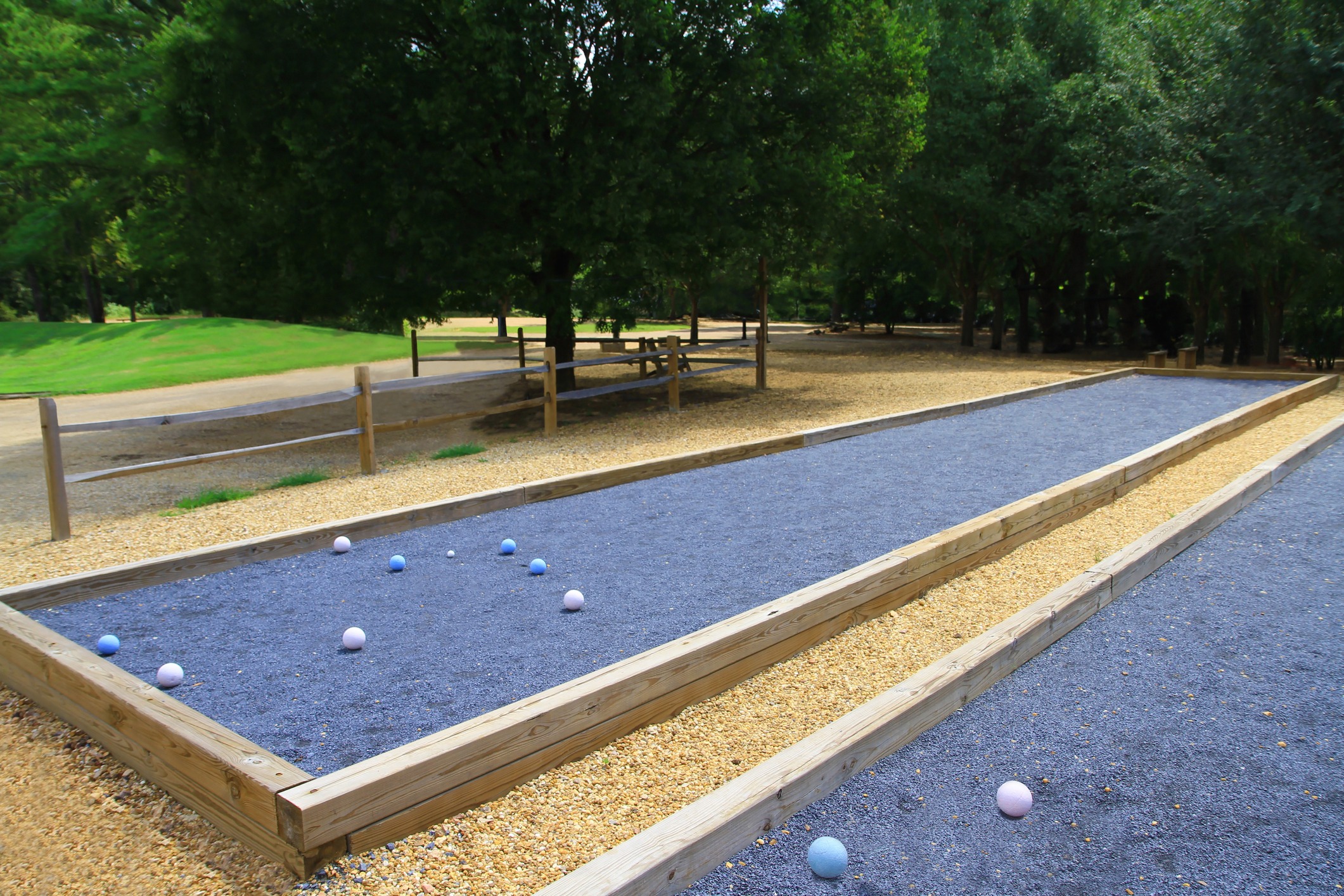 Outdoor bocce ball court in tree-lined park